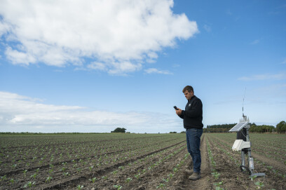 Man in paddock with soil monitoring equipment